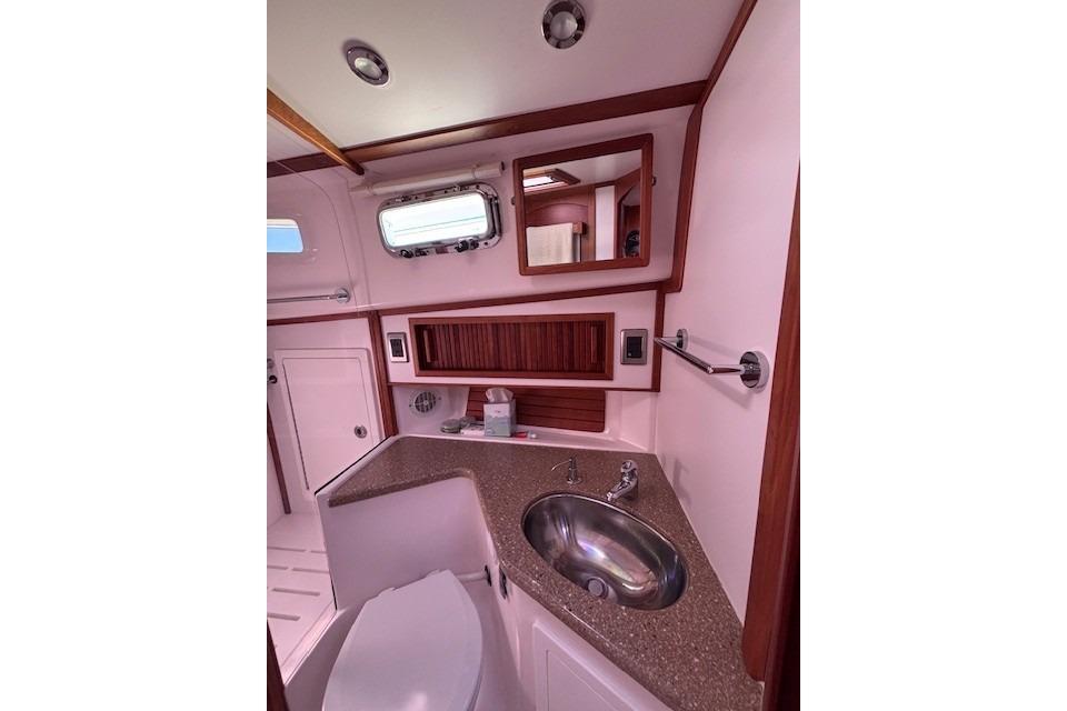 2012 Sabre 42 Salon Express bathroom with sink, mirror, and porthole window.
