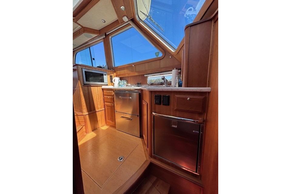 Interior of 2012 Sabre 42 Salon Express yacht with wooden cabinetry and modern appliances.