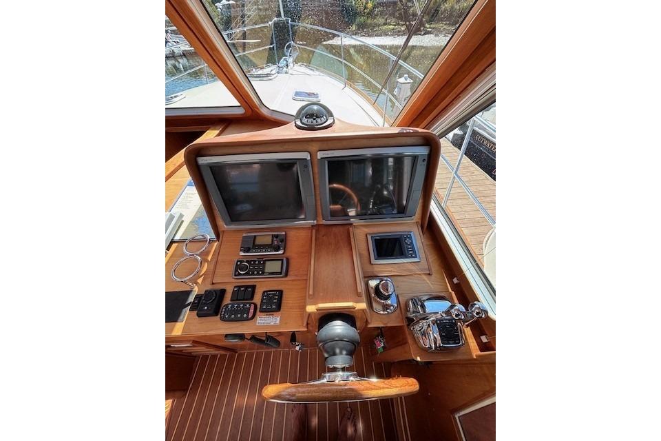 2012 Sabre 42 Salon Express helm with dual screens and wooden dashboard.