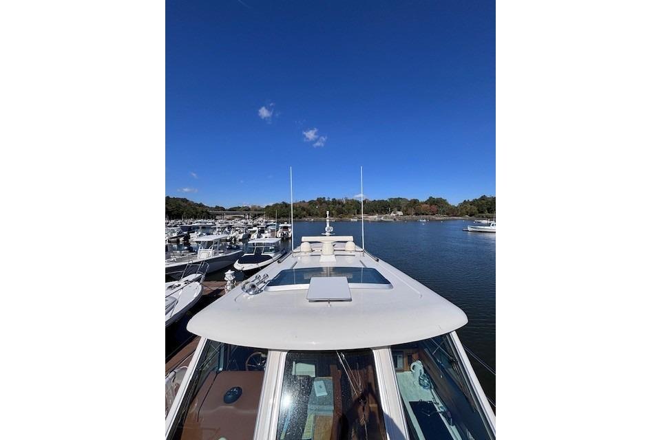 2012 Sabre 42 Salon Express yacht docked in a marina under clear blue skies.
