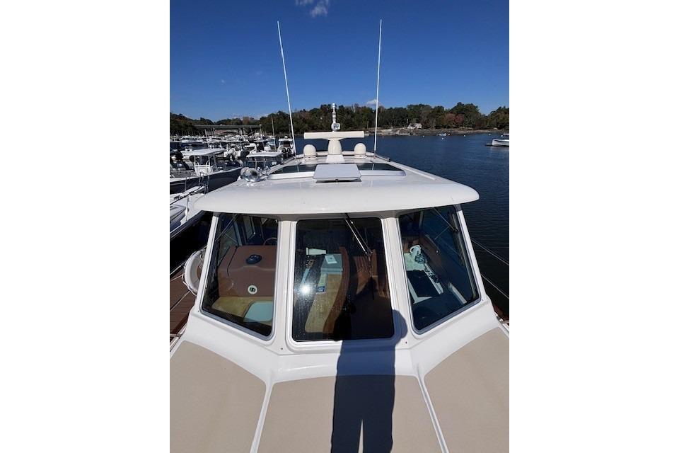2012 Sabre 42 Salon Express yacht docked at marina under clear blue sky.
