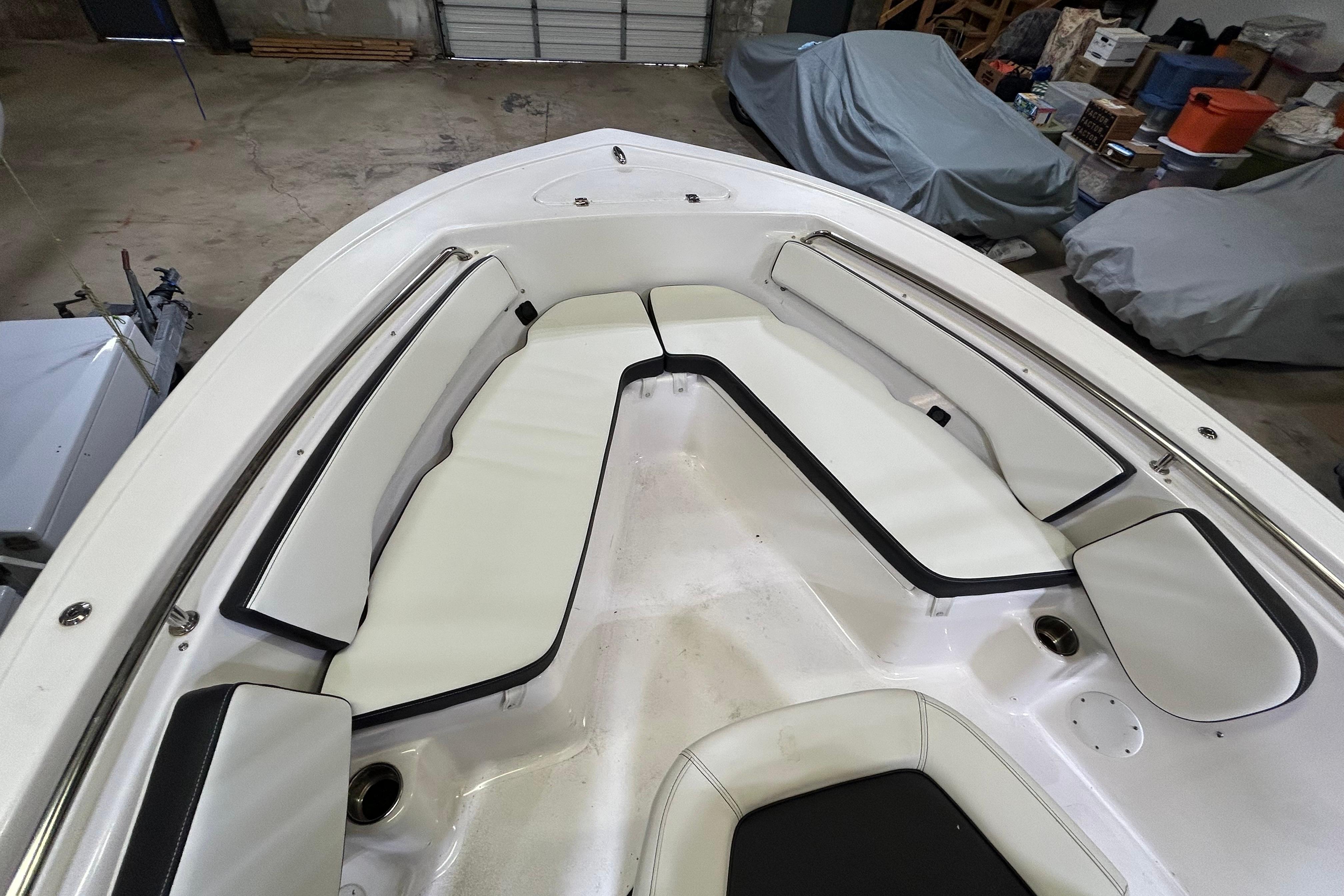 2024 Tidewater 198 CC Adventure boat interior with white cushioned seating in a garage setting.
