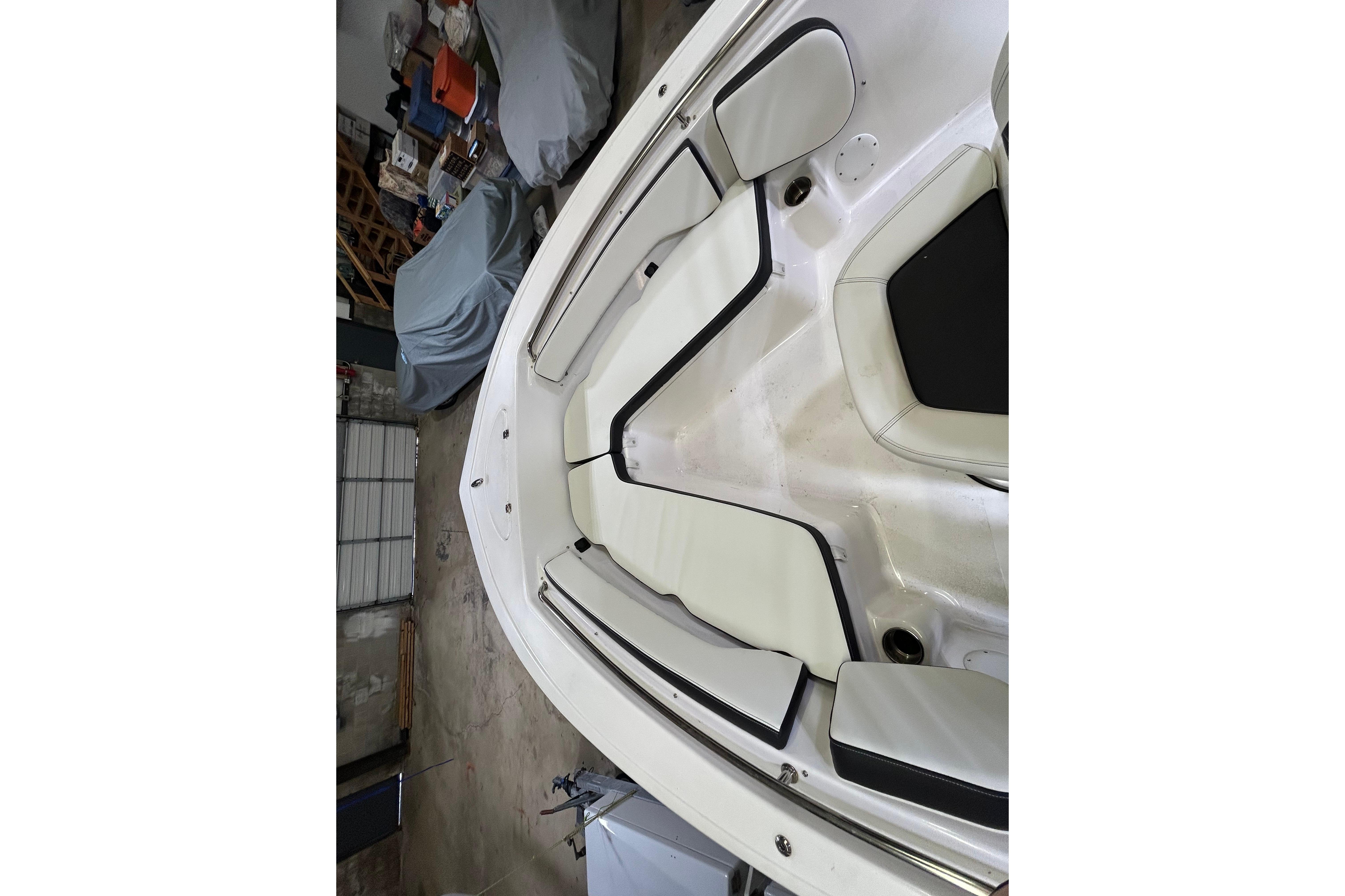 2024 Tidewater 198 CC Adventure boat interior with cushioned seating in a garage.