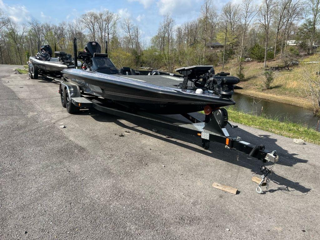 2022 Bullet 21XRS boat on trailer, parked near a scenic riverbank.