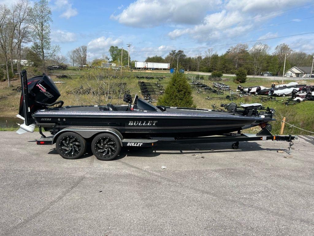 2022 Bullet 21XRS boat on trailer, parked outdoors under a partly cloudy sky.