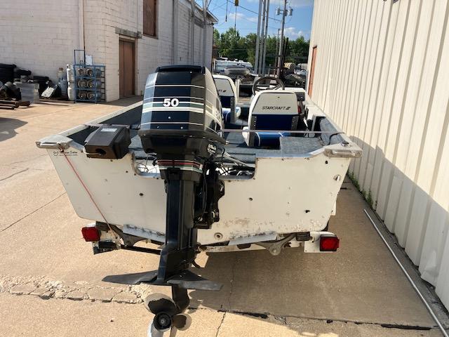 1992 Starcraft FM 160C boat with 50 HP outboard motor, parked outdoors.