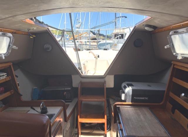 Interior view of a 1979 Lancer Sloop sailboat with marina background.