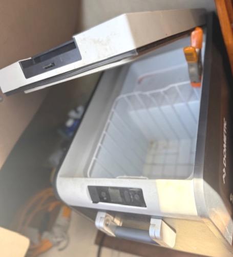 Open portable cooler inside a 1979 Lancer Sloop boat, showing interior storage space.