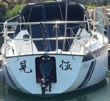 1979 Lancer Sloop boat docked, featuring distinctive black lettering on the hull.