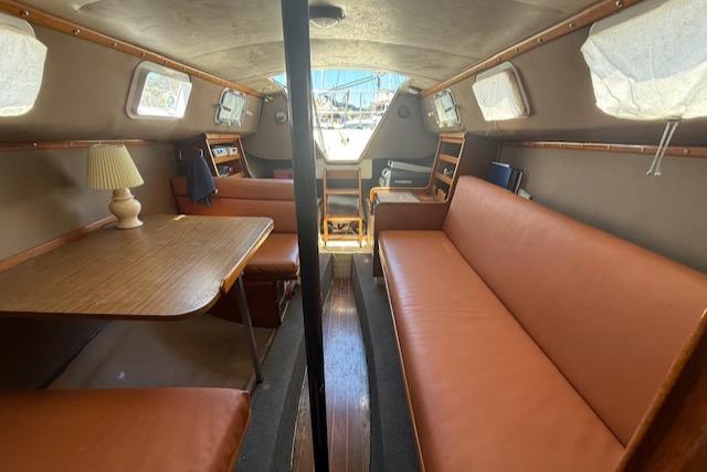 1979 Lancer Sloop interior with brown seating, wooden table, and nautical decor.