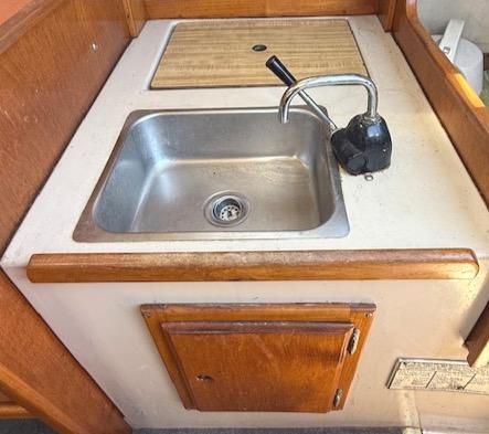 1979 Lancer Sloop kitchen sink with wooden cabinetry and faucet.
