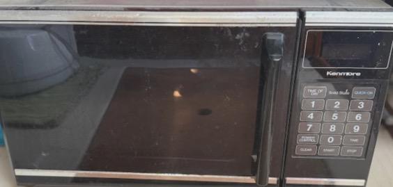 Vintage Kenmore microwave with keypad, black finish, and reflective door.