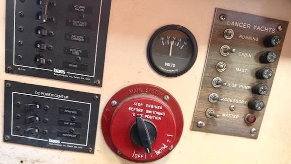 Control panel of a 1979 Lancer Sloop yacht with switches and voltmeter.