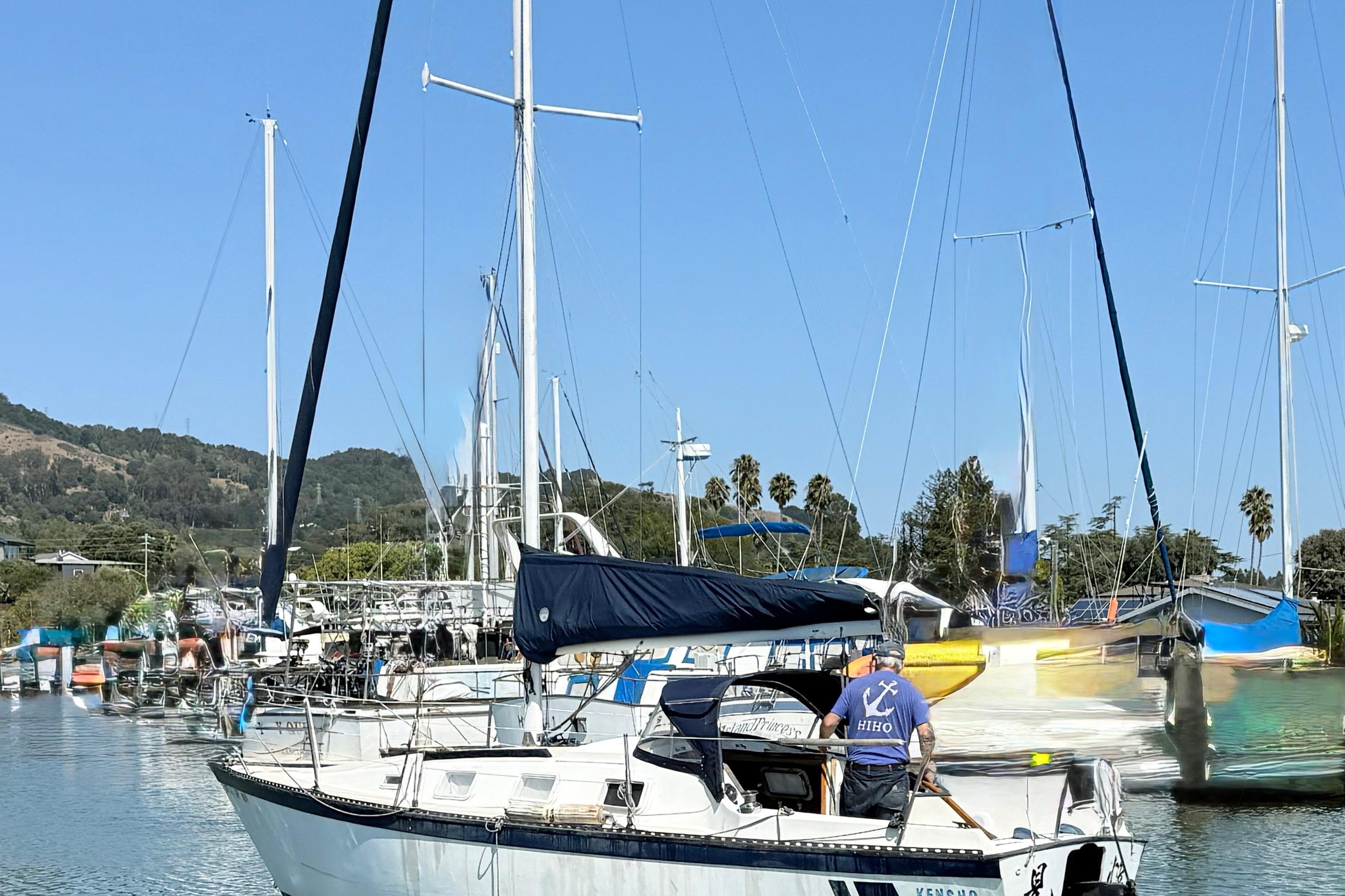 1979 Lancer Sloop sailboat docked in a marina with clear blue skies.