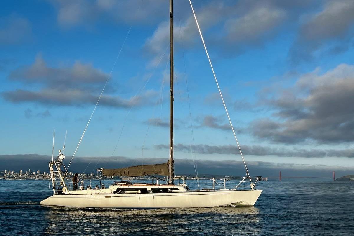 1982 Santa Cruz 50 sailboat cruising on calm waters under a clear blue sky.