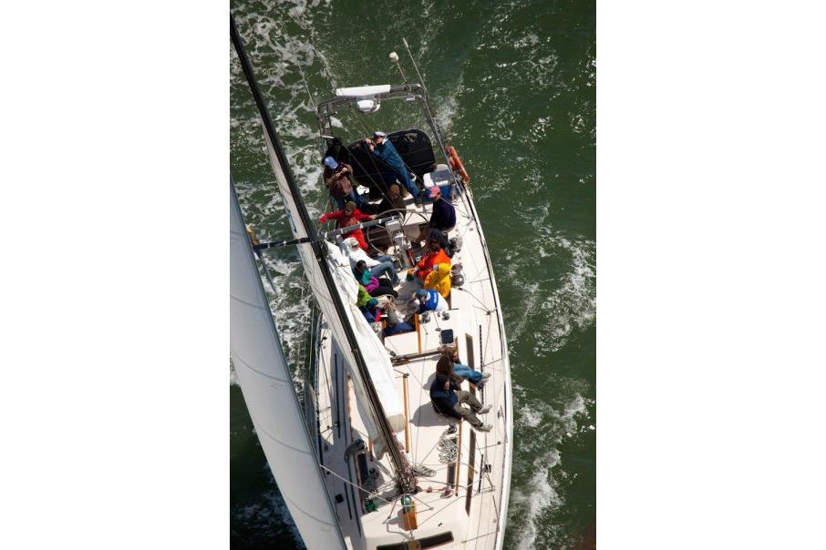 Aerial view of 1982 Santa Cruz 50 sailboat with crew navigating through water.