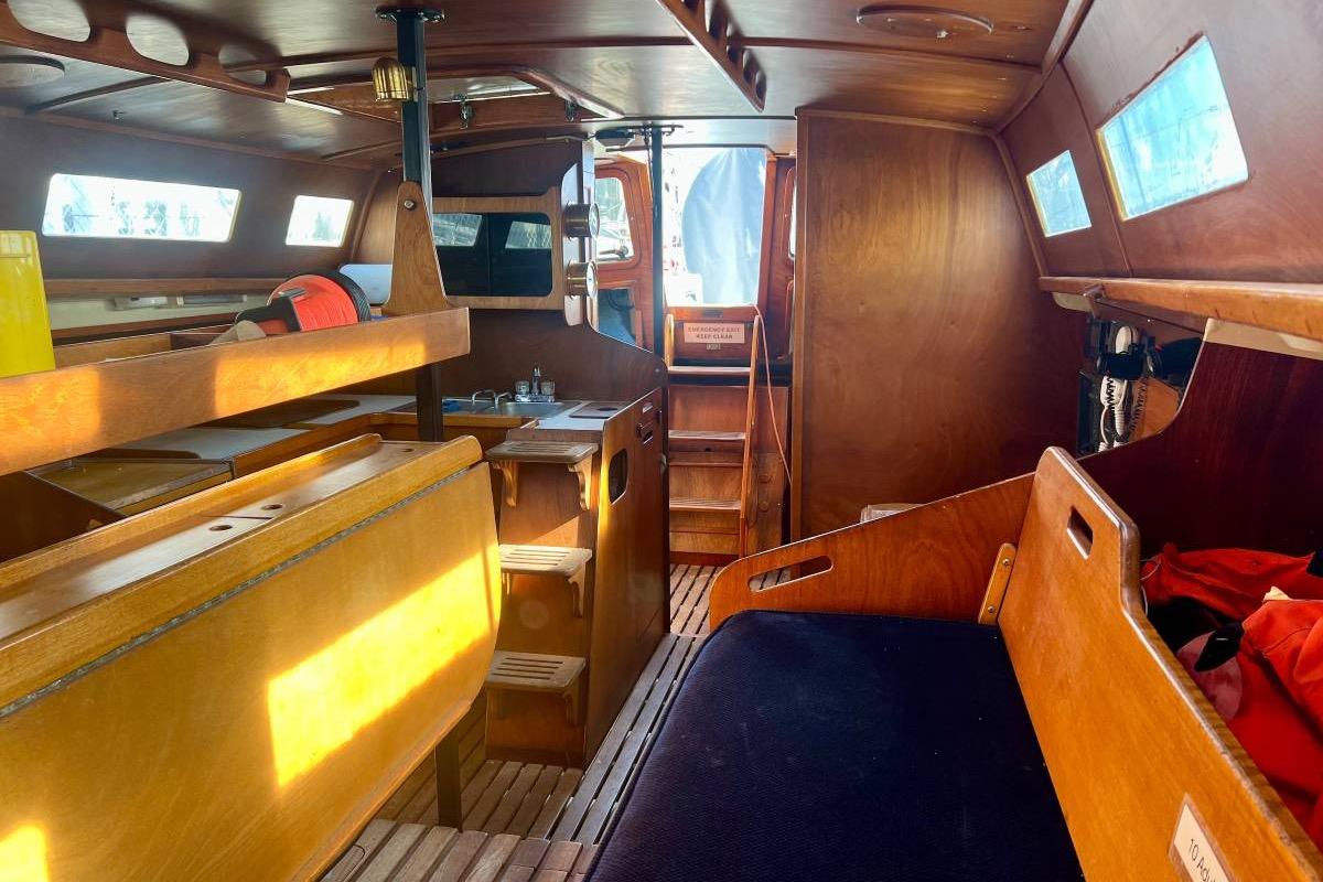 Interior of a 1982 Santa Cruz 50 sailboat with wooden furnishings and seating.