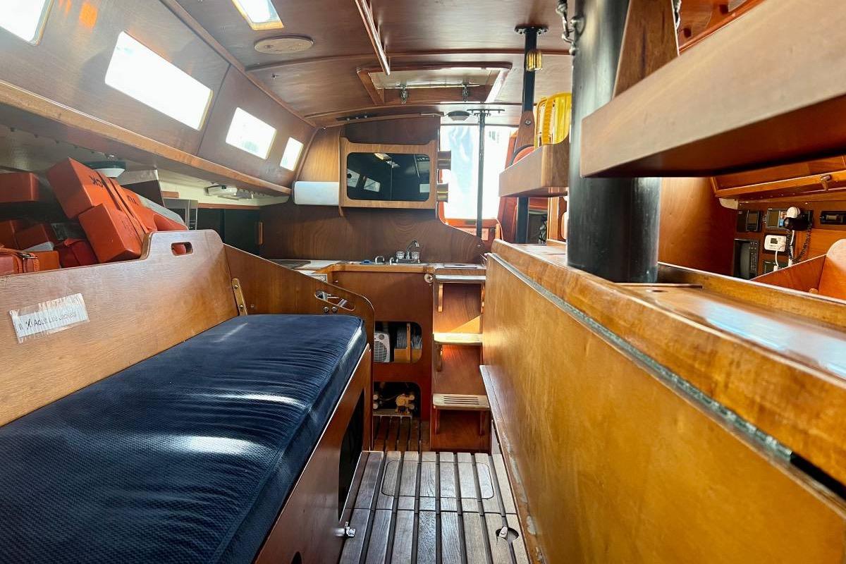 Interior of a 1982 Santa Cruz 50 sailboat, featuring wooden furnishings and cozy seating.