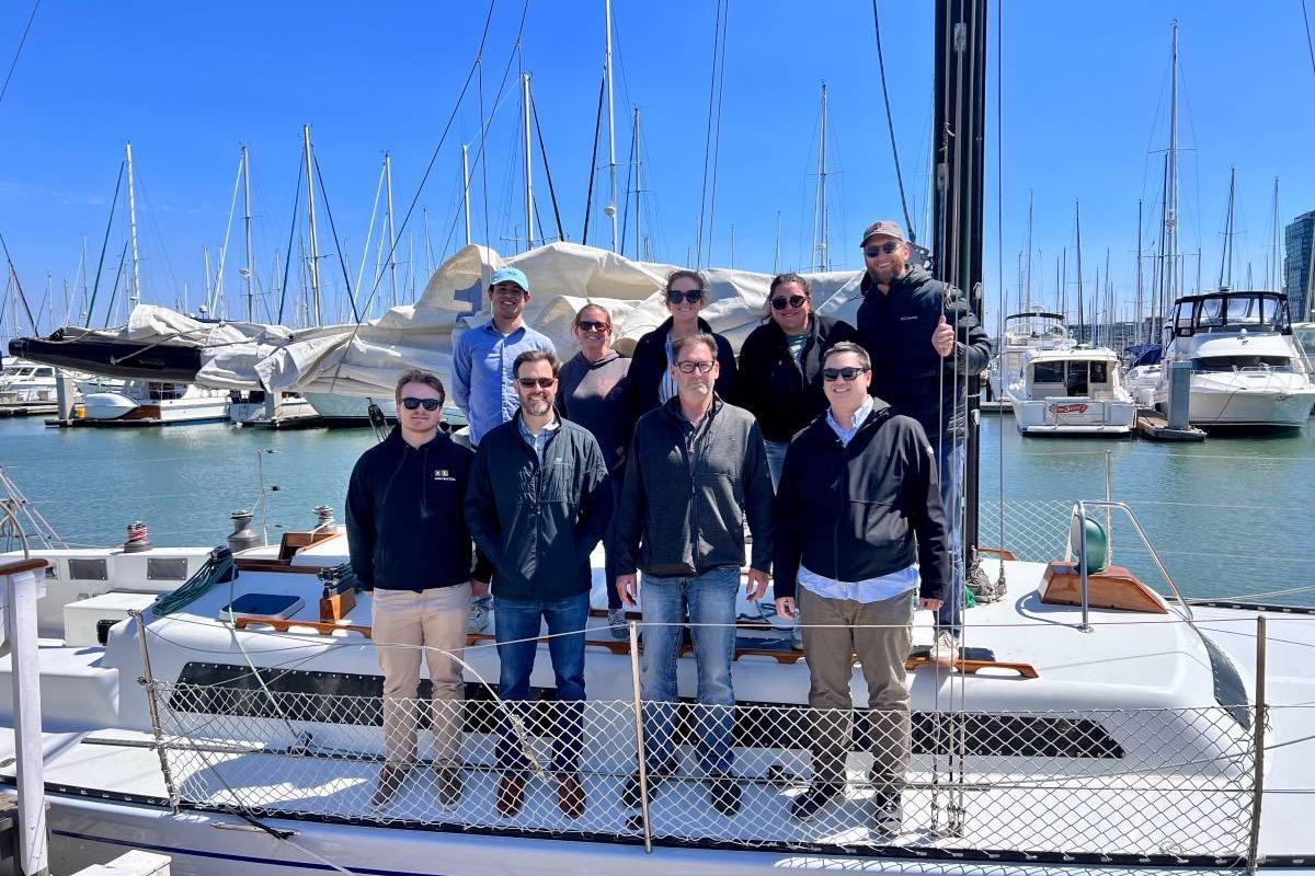 Group of people on a 1982 Santa Cruz 50 sailboat at a marina.