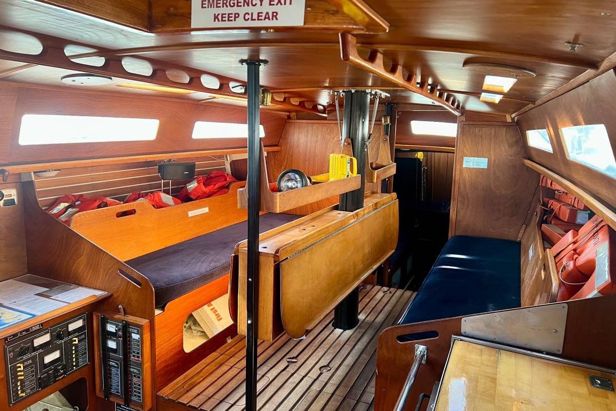 Interior of a 1982 Santa Cruz 50 sailboat with wooden furnishings and life jackets.