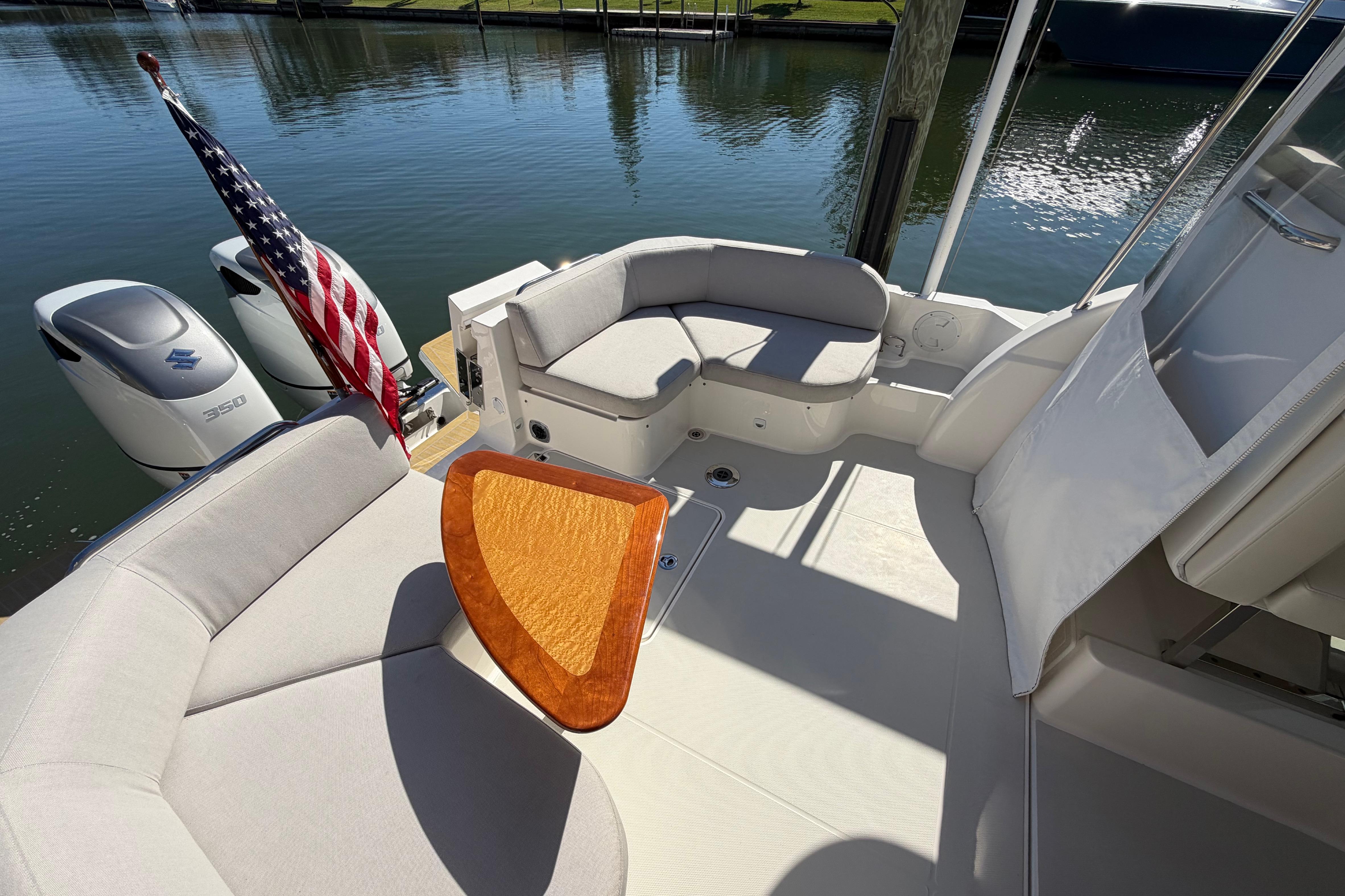 2023 Back Cove 340 boat interior with seating, table, and American flag.