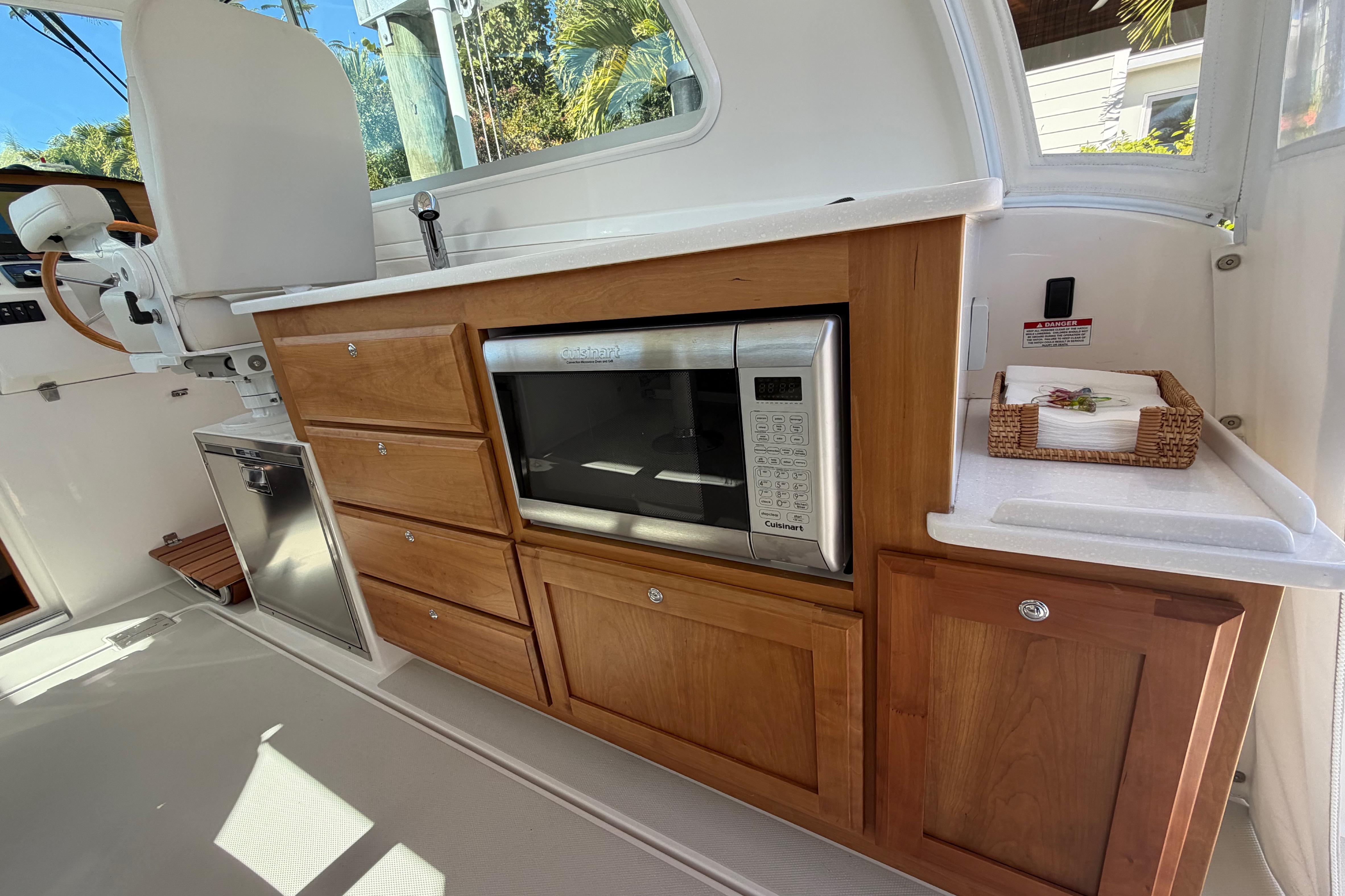 2023 Back Cove 340 interior with wooden cabinetry and built-in microwave.