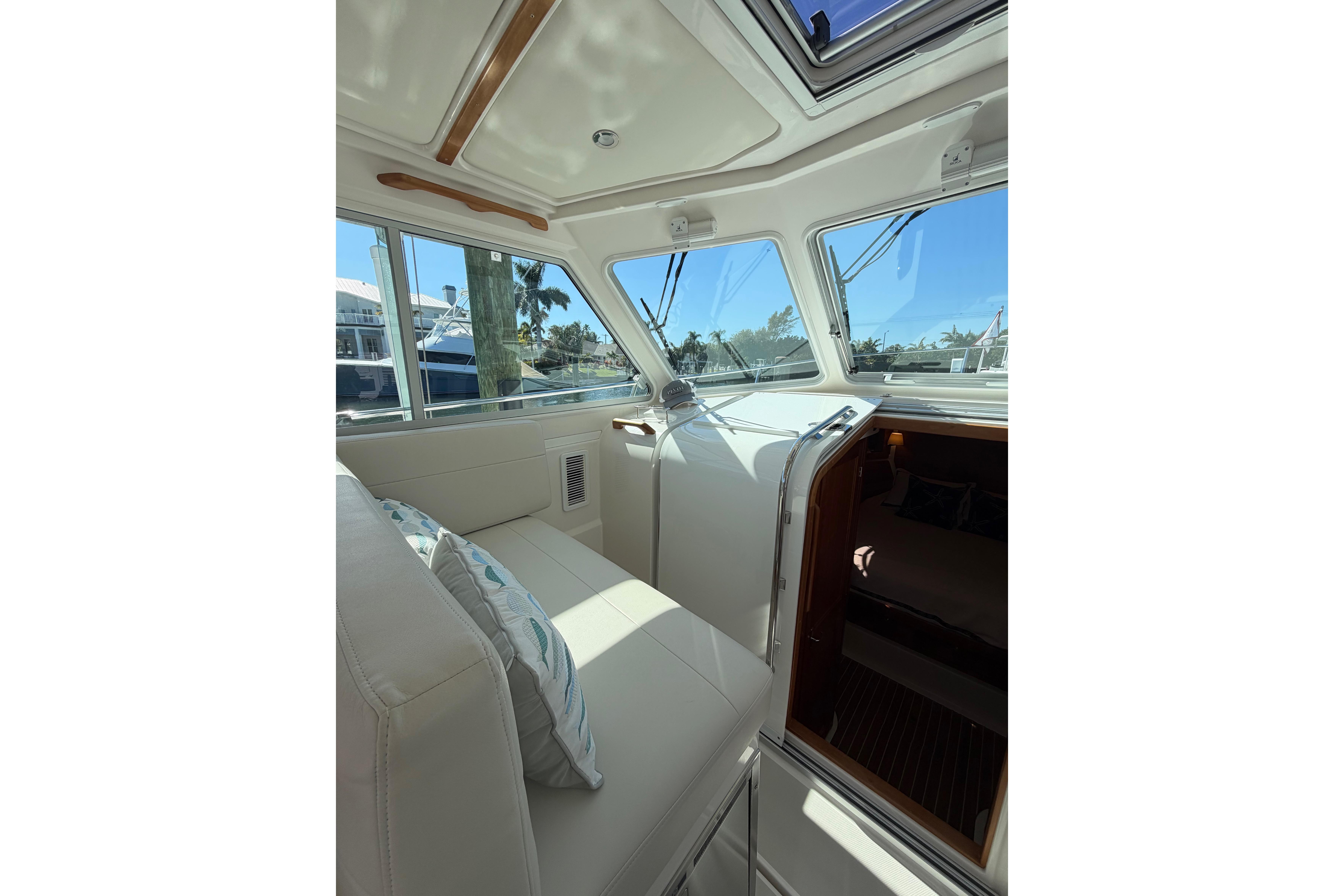 Interior of 2023 Back Cove 340 boat with plush seating and large windows.