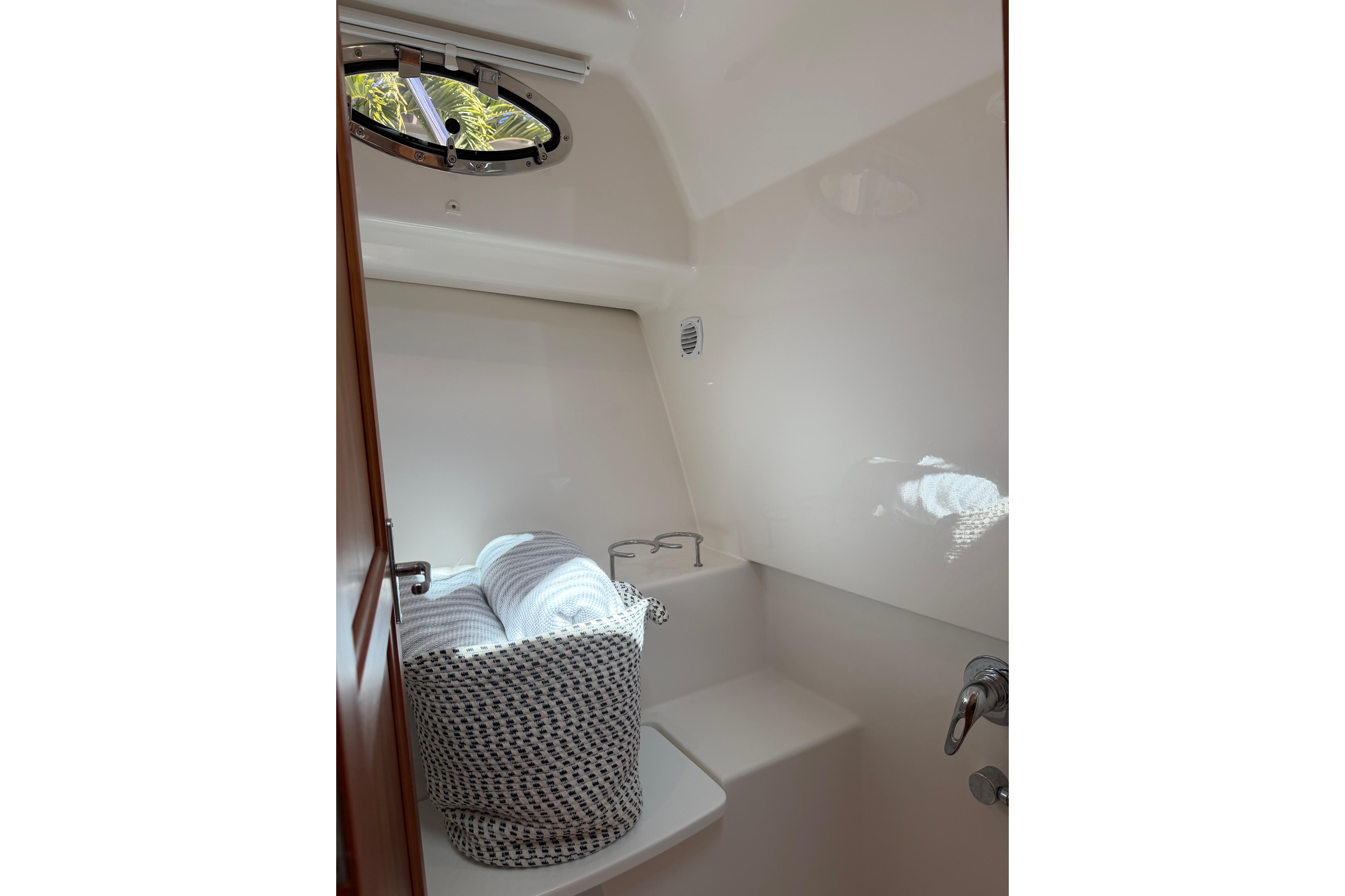2023 Back Cove 340 interior with porthole, featuring a cozy seating area and soft lighting.