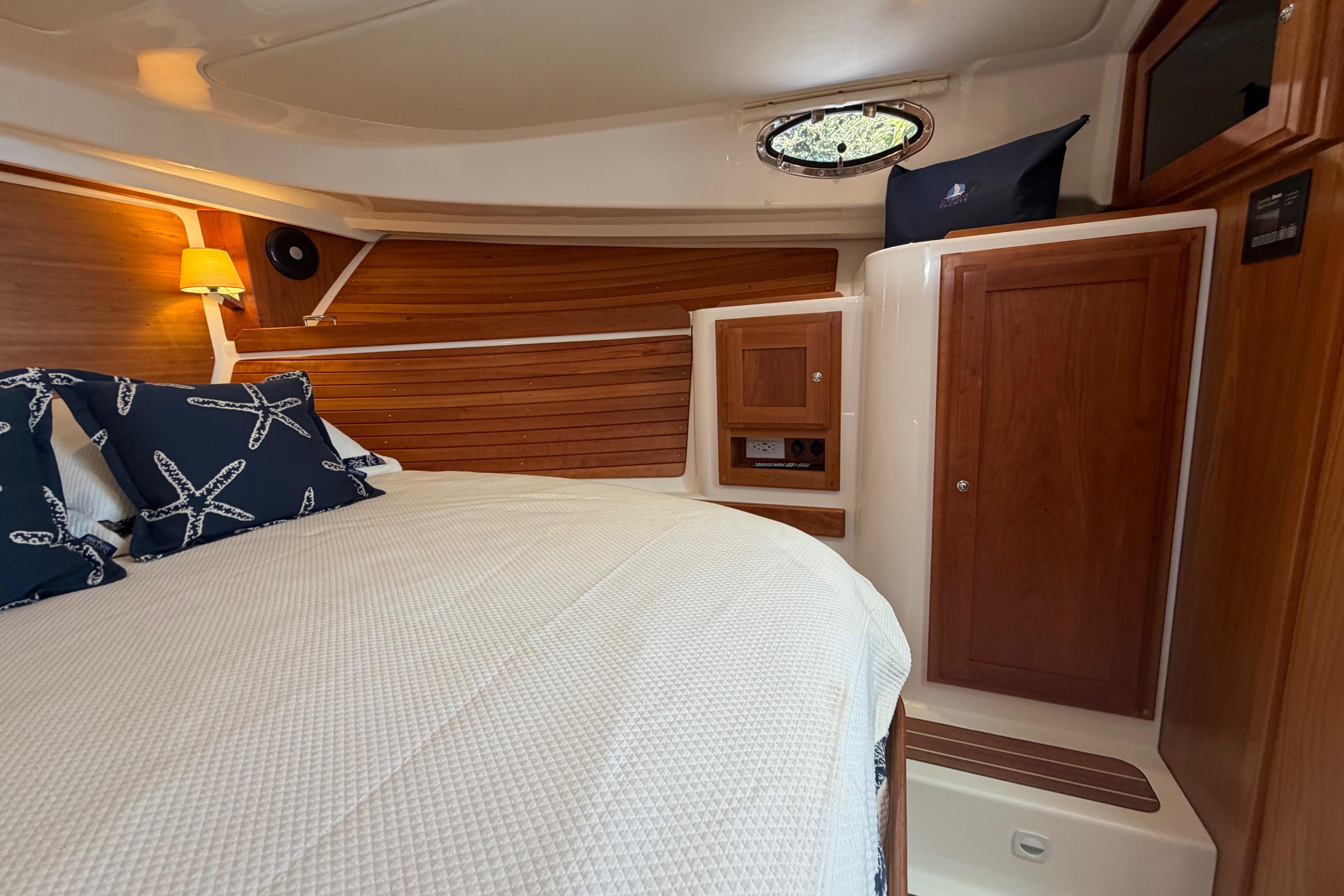 2023 Back Cove 340 cabin interior with wood paneling and cozy bedding.