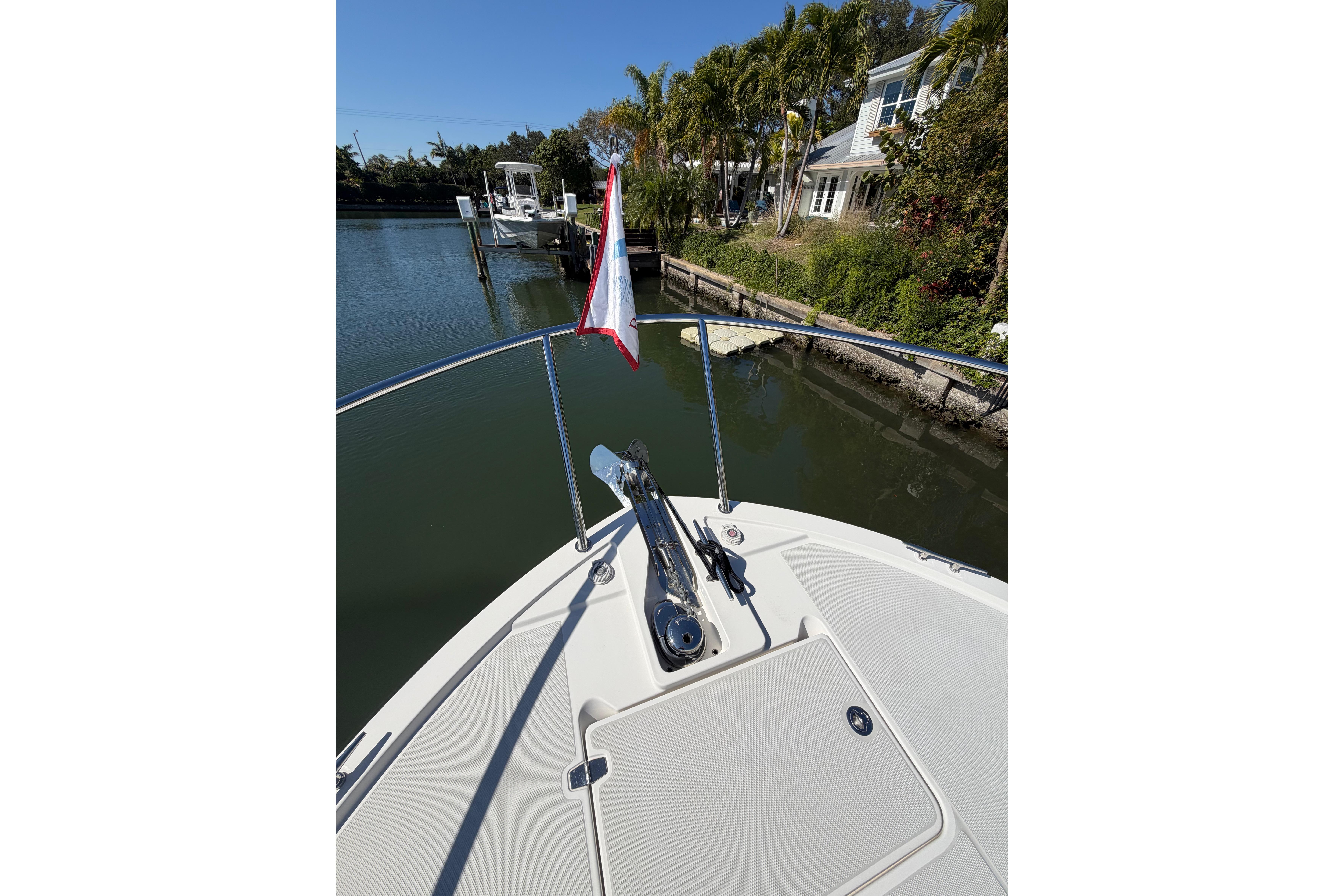 2023 Back Cove 340 boat bow with anchor, docked near waterfront homes.