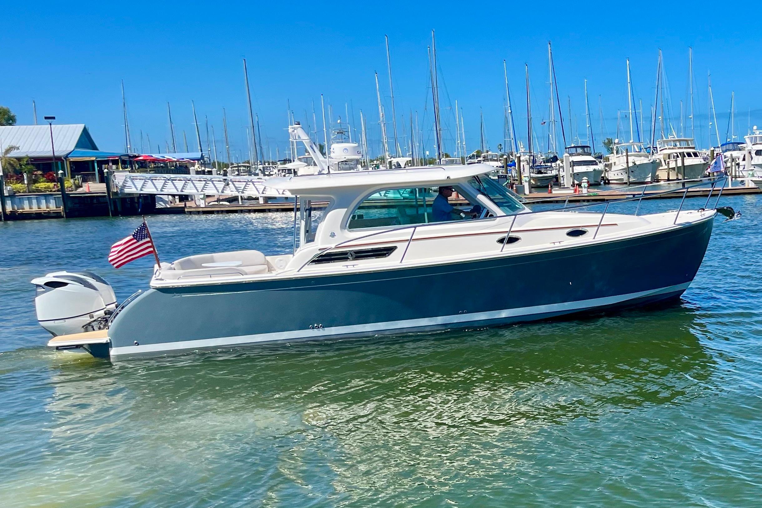 2023 Back Cove 340 boat cruising in a marina with American flag.
