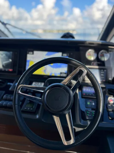 Seven Yacht Photos Pics Steering wheel and dashboard of 2018 Princess V58 yacht with navigation screens.