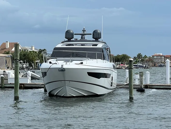 Seven Yacht Photos Pics 2018 Princess V58 yacht docked in a marina with waterfront homes in the background.