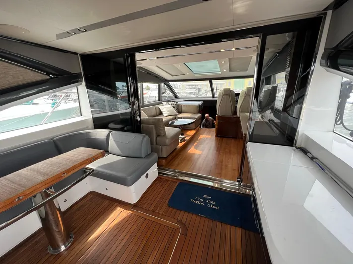 Seven Yacht Photos Pics Luxurious interior of 2018 Princess V58 yacht with elegant seating and wooden flooring.