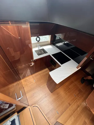 Seven Yacht Photos Pics Luxurious kitchen interior of 2018 Princess V58 yacht with modern appliances and wood finish.