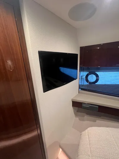 Seven Yacht Photos Pics Interior of 2018 Princess V58 yacht with wall-mounted TV and window view.