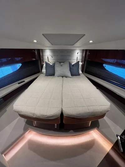 Seven Yacht Photos Pics Luxurious interior of 2018 Princess V58 yacht with elegant bedding and ambient lighting.