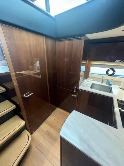 Seven Yacht Photos Pics Luxurious 2018 Princess V58 yacht interior with modern kitchen and wooden cabinetry.