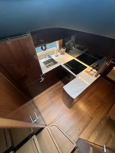 Seven Yacht Photos Pics Luxurious 2018 Princess V58 yacht kitchen with modern appliances and wooden cabinetry.