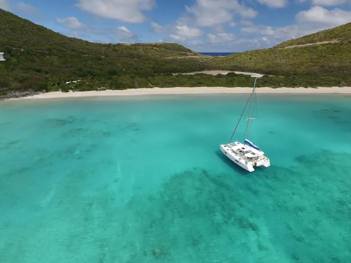 Blind Ambition II Yacht Photos Pics Lagoon 42 catamaran anchored in turquoise waters near a secluded beach, 2020 model.