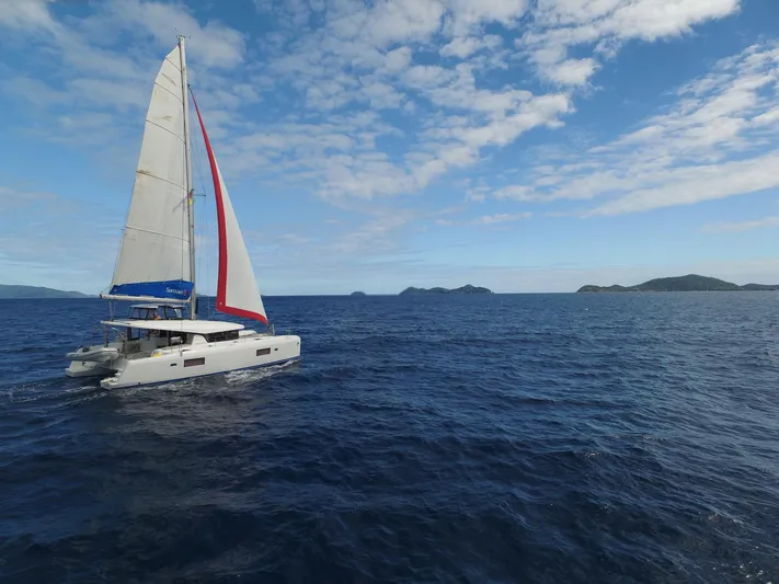 Blind Ambition II Yacht Photos Pics Lagoon 42 catamaran sailing in open sea, 2020 model, under a partly cloudy sky.