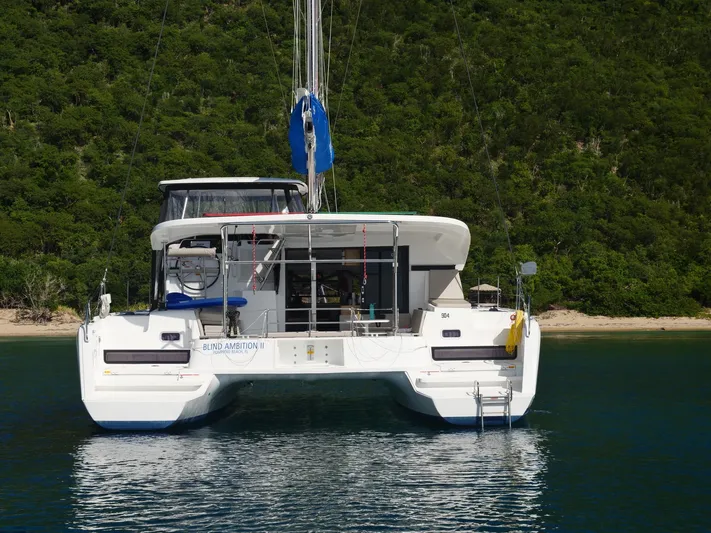 Blind Ambition II Yacht Photos Pics 2020 Lagoon 42 catamaran anchored near lush green shoreline.