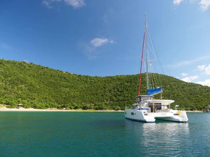 Blind Ambition II Yacht Photos Pics Lagoon 42 catamaran (2020) anchored in a serene tropical bay with lush green hills.
