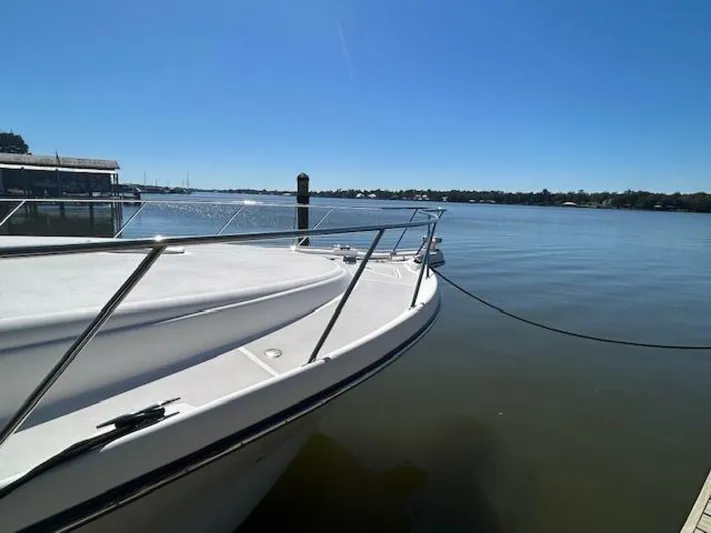 Absolutely Yacht Photos Pics 2006 Tiara Yachts Open docked by a serene waterfront under clear blue skies.