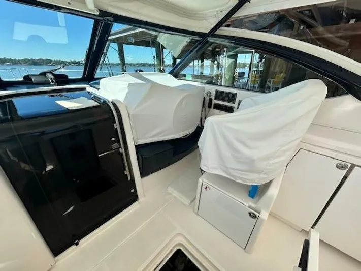 Absolutely Yacht Photos Pics 2006 Tiara Yachts Open cockpit with covered seats and control panel, docked by the water.