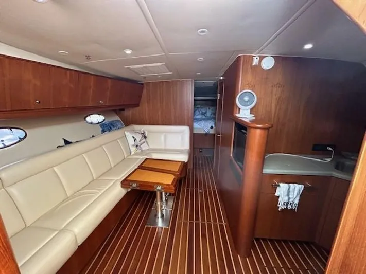 Absolutely Yacht Photos Pics 2006 Tiara Yachts Open interior with wood finish, beige seating, and compact kitchen area.