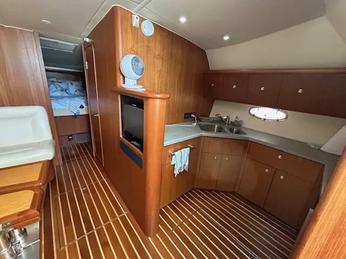 Absolutely Yacht Photos Pics 2006 Tiara Yachts Open interior with wood finish, kitchenette, and cozy sleeping area.