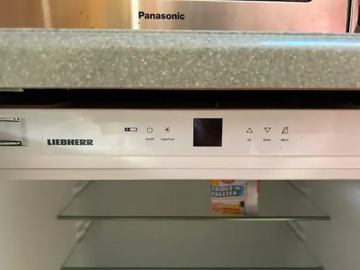 Absolutely Yacht Photos Pics Liebherr refrigerator control panel with Panasonic appliance above, showcasing modern kitchen design.