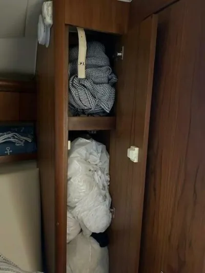 Absolutely Yacht Photos Pics Wooden cabinet with clothes and bedding inside, aboard a 2006 Tiara Yachts Open.