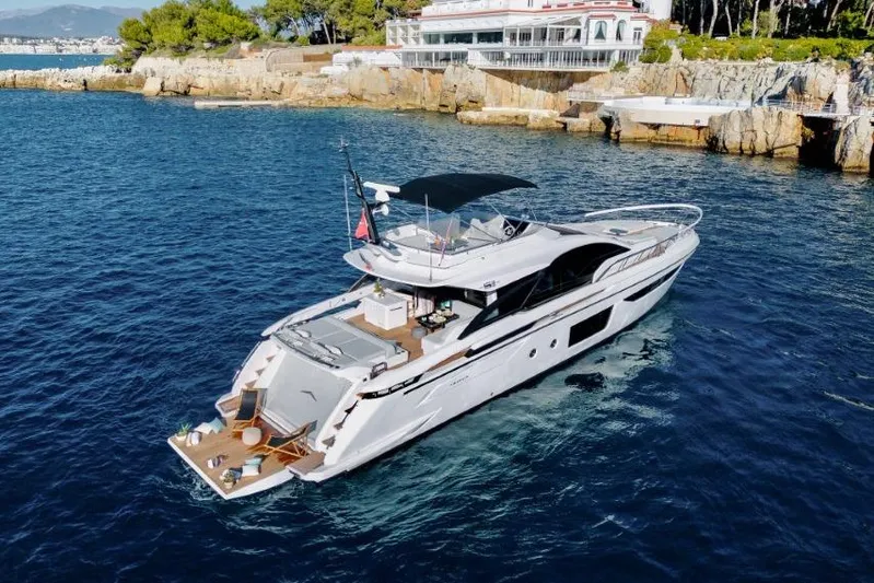  Yacht Photos Pics 2023 Azimut S8 luxury yacht cruising near rocky coastline and elegant waterfront building.